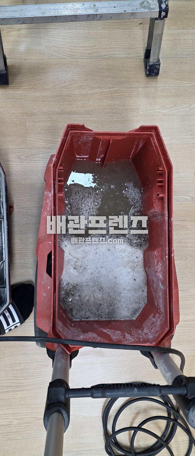 배관에서 걷어낸 찌꺼기를 담은 통