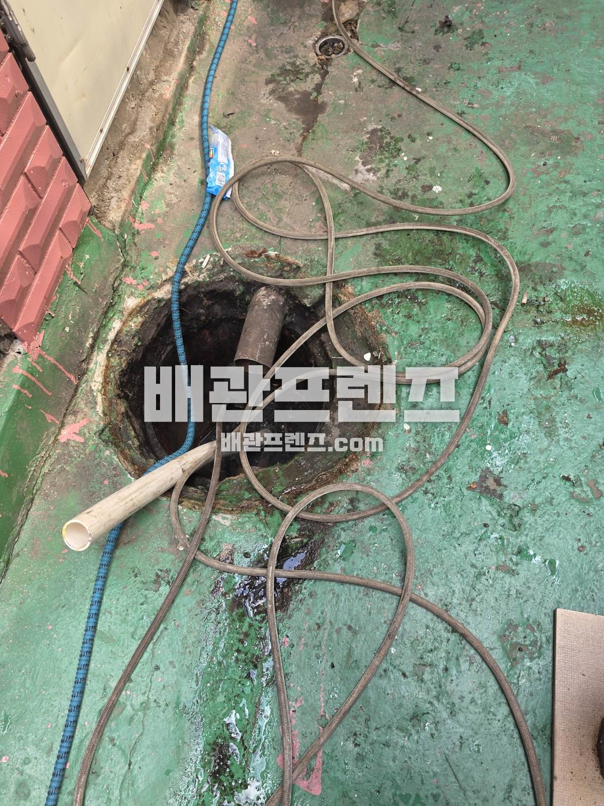 통로 바닥 배수구에 장비 호스와 케이블을 넣은 모습