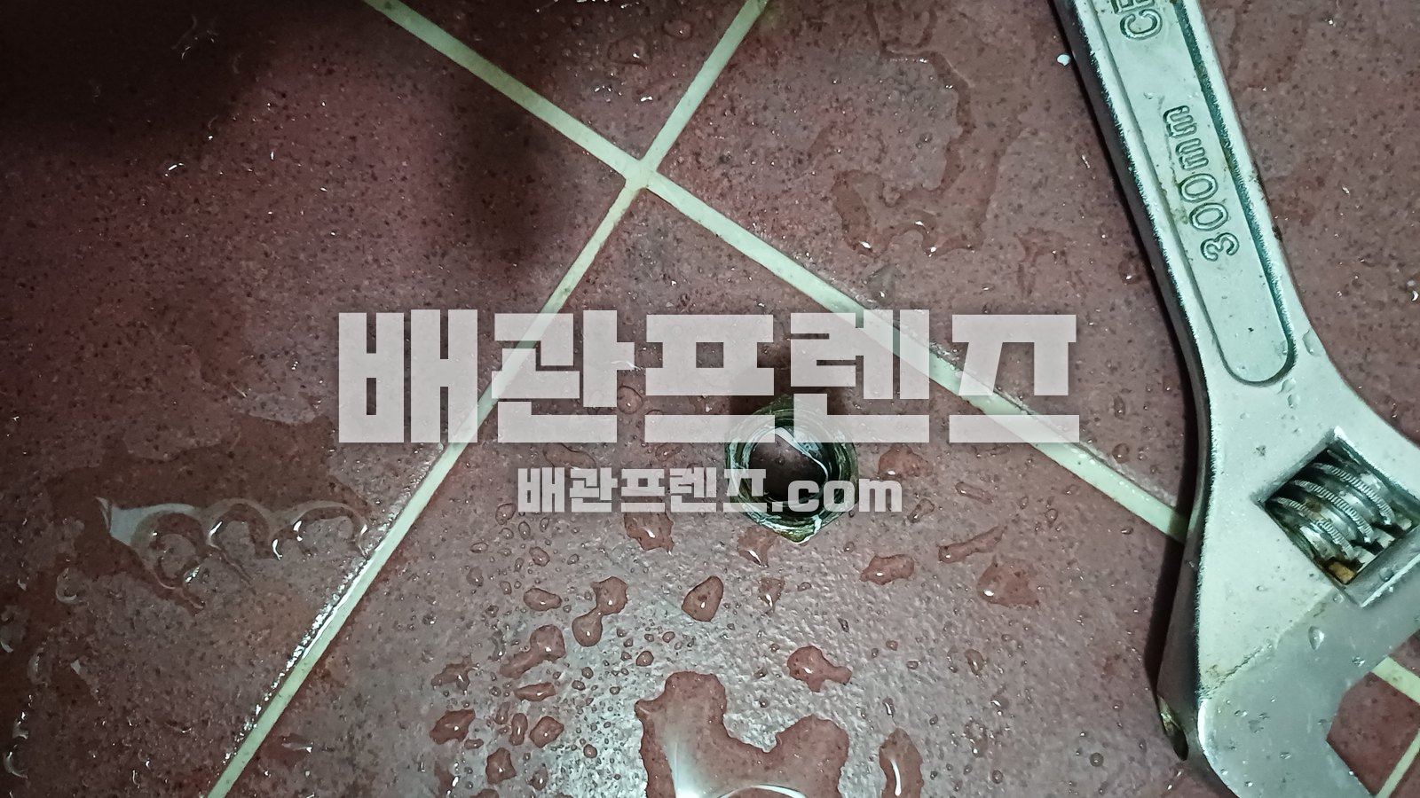 욕실 바닥 배수구와 렌치