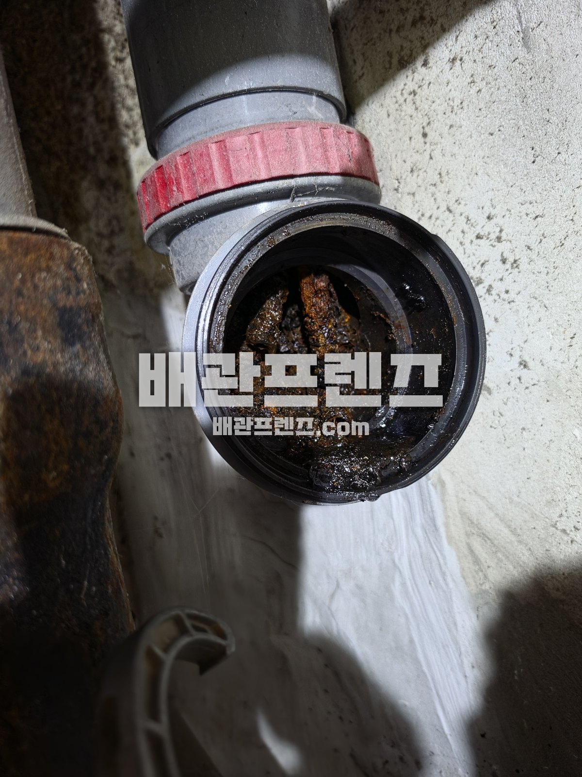 찌꺼기가 쌓인 배수관 이음 부속 안쪽