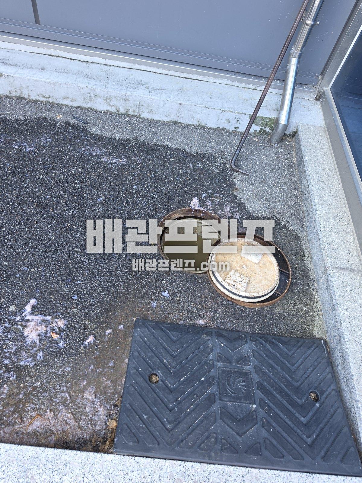 건물 앞 바닥의 열어 둔 배수 맨홀