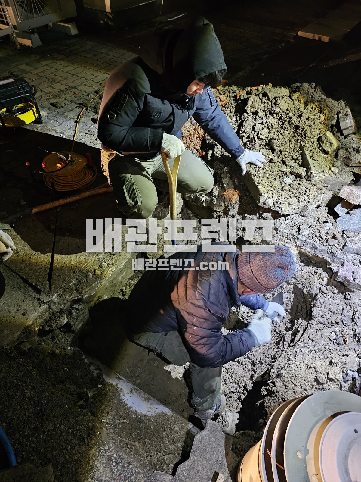 바닥과 지면을 열어 매설 배관을 드러낸 굴착 작업 장면