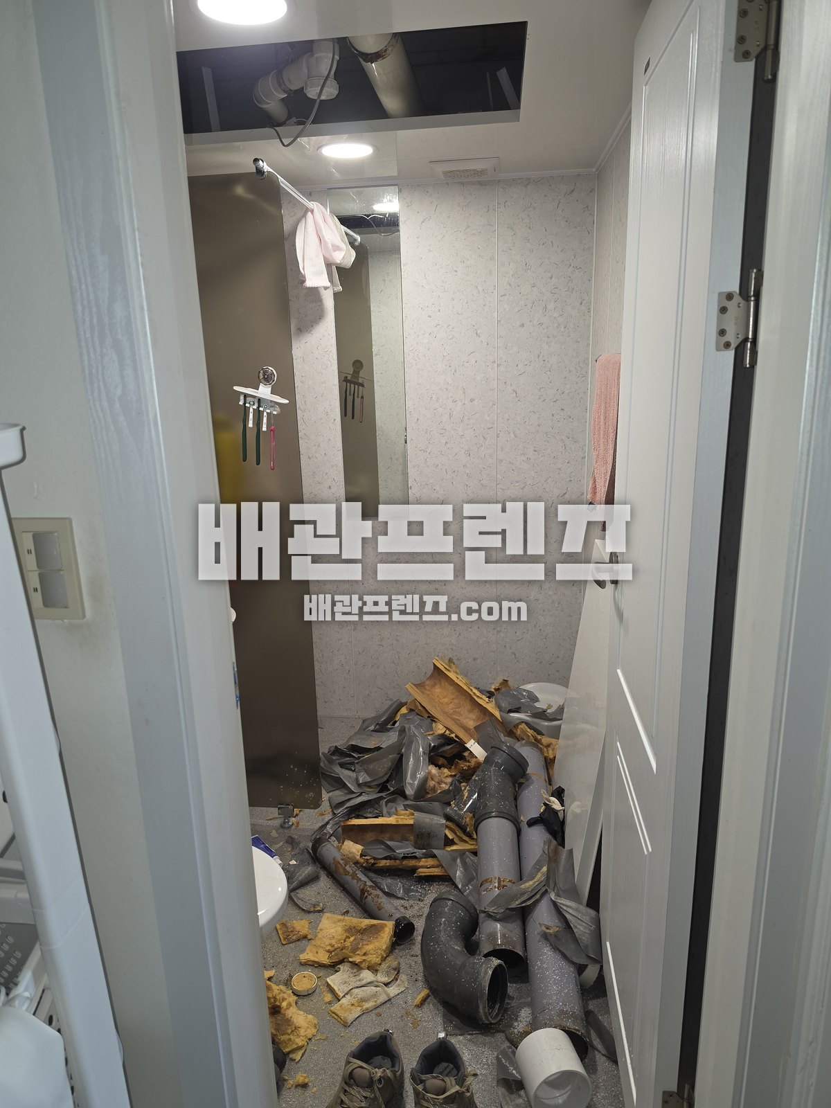천장과 바닥을 열고 철거한 배관이 쌓여 있는 욕실