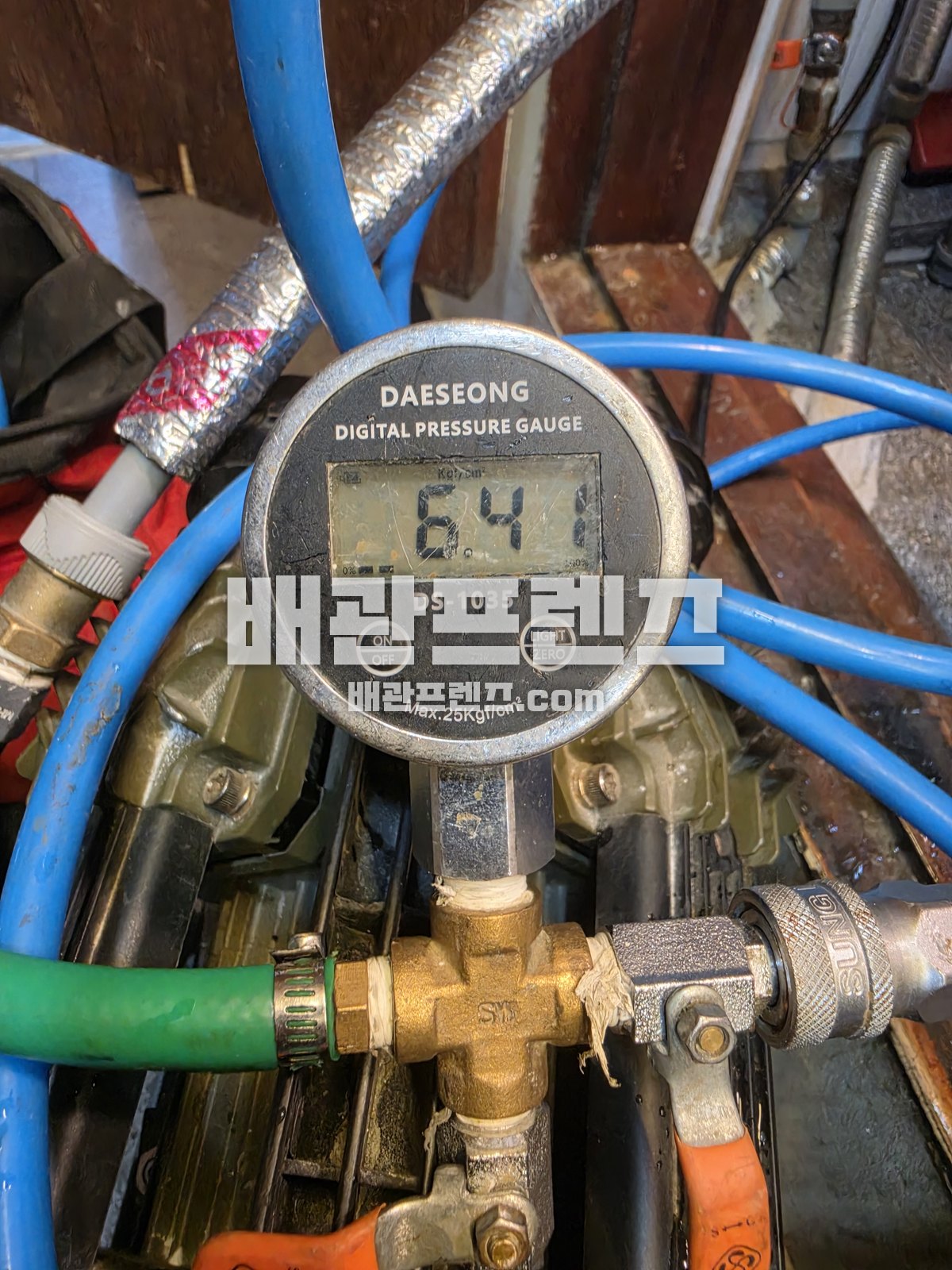 배관 수압을 확인하는 디지털 압력계와 연결 호스